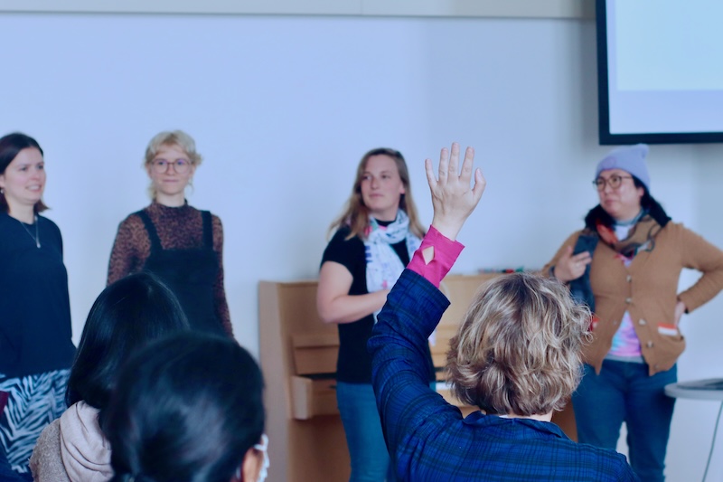 A person raising their hand to ask a question.
